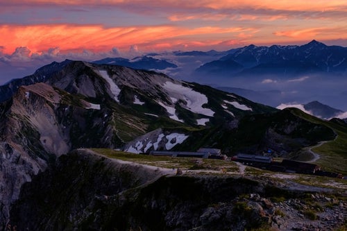 夕日に染まる杓子岳と白馬鑓ヶ岳と立山連峰の写真