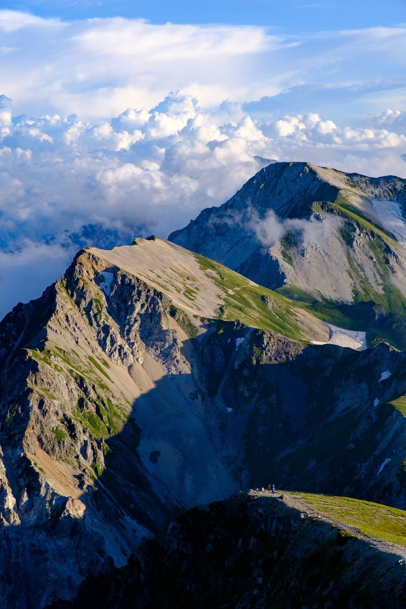 「登山道を歩く登山者と杓子岳」の写真