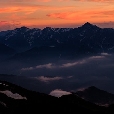 白馬岳から望む夕日に染まる立山連峰の写真