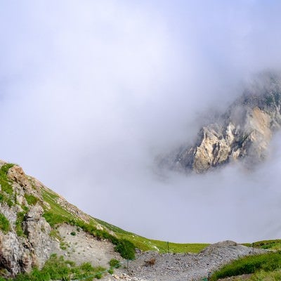 白馬岳山頂からみたガスの合間の岩山の写真