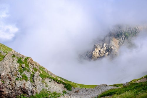 白馬岳山頂からみたガスの合間の岩山の写真