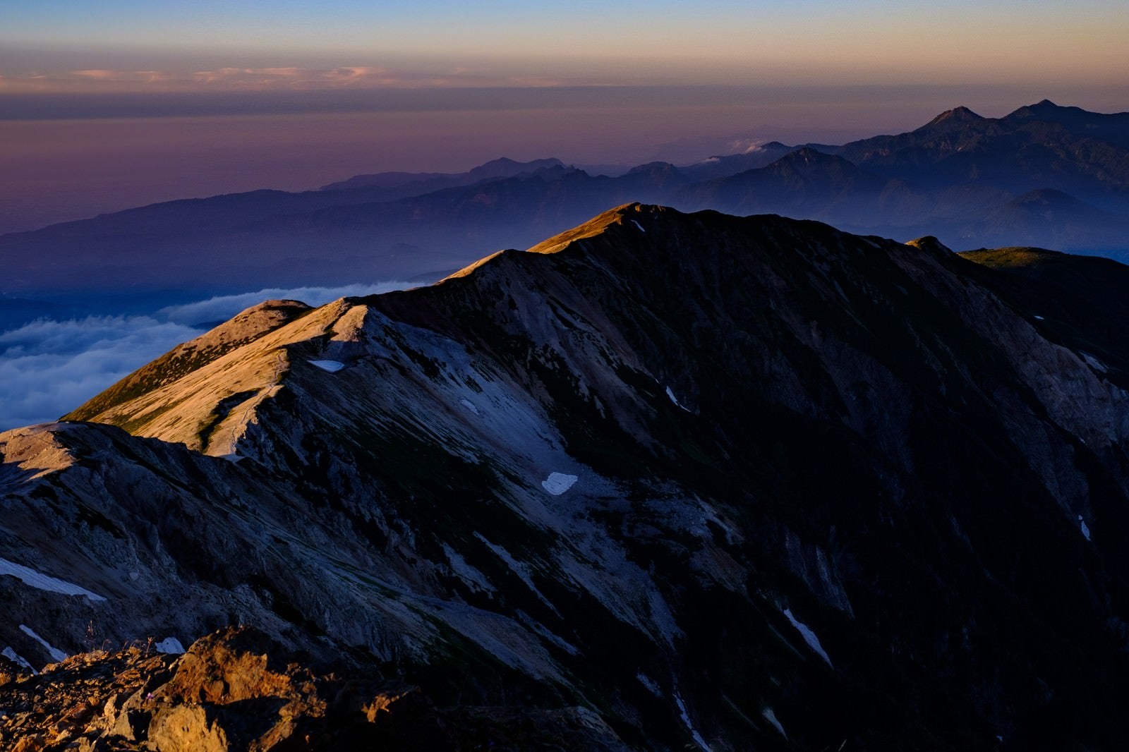 「白馬岳山頂から望む夕日に染まる稜線」の写真
