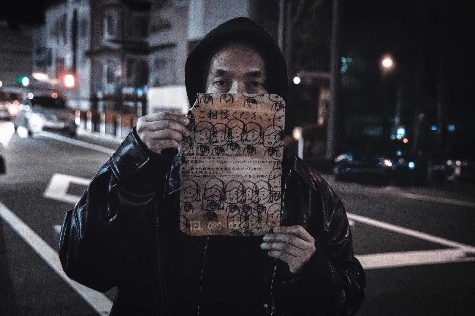 「闇バイト勧誘怪文書を掲げるスカウト」の写真［モデル：大川竜弥］