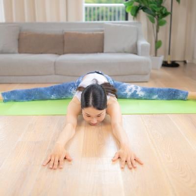 下半身の柔軟性を養う開脚前屈ポーズの女性の素材