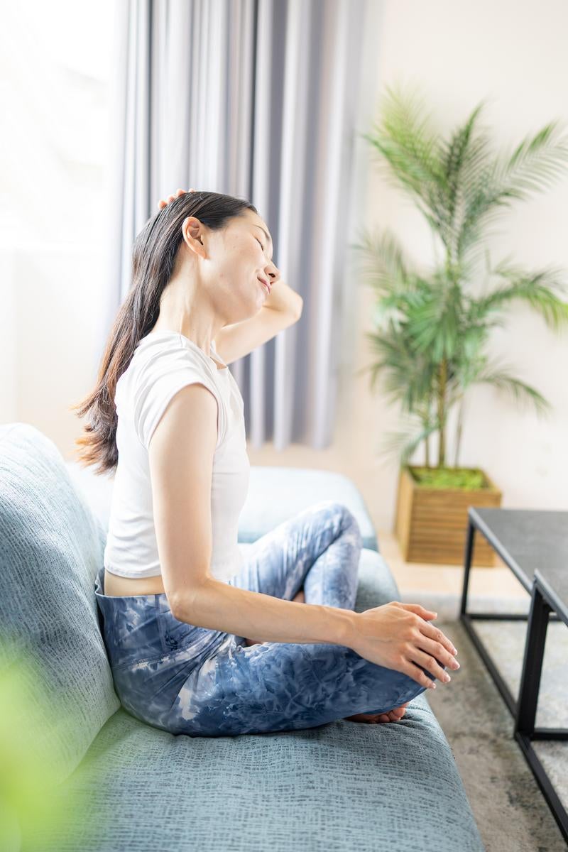 朝の室内でストレッチをする女性の写真