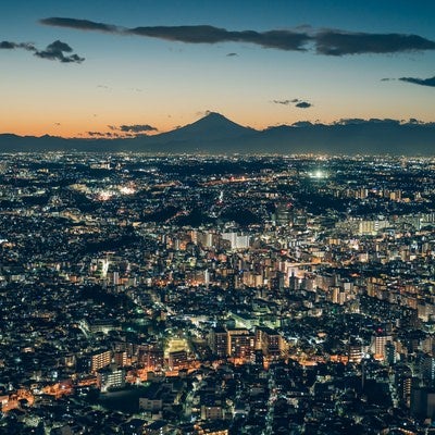 遠くに見える富士山のシルエットと横浜の夜景の写真