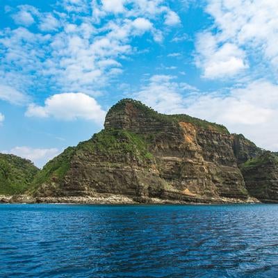 縞状地層が露出する徳之島の断崖絶壁の写真