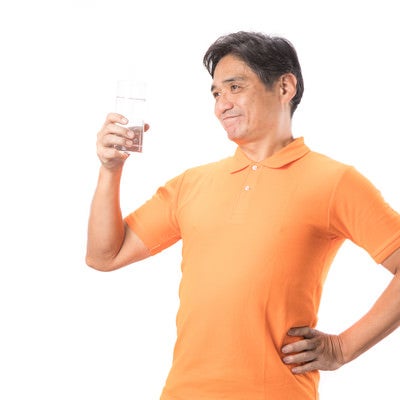 こまめな水分補給が健康の証！と胸をはる中年男性の写真