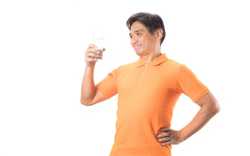 こまめな水分補給が健康の証！と胸をはる中年男性の写真