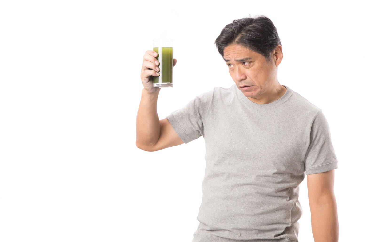 「勧められた青汁を手に取る中年男性」の写真［モデル：よたか］