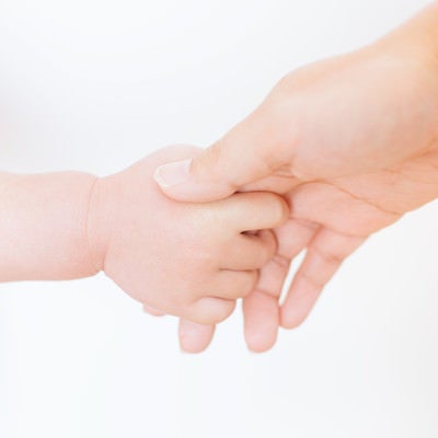 親の手を握る赤ちゃんの手の写真