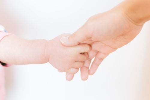 親の手を握る赤ちゃんの手の写真