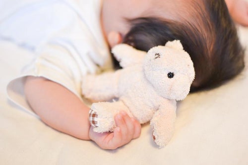 ぬいぐるみをギュッとする赤ちゃん(把握反射)