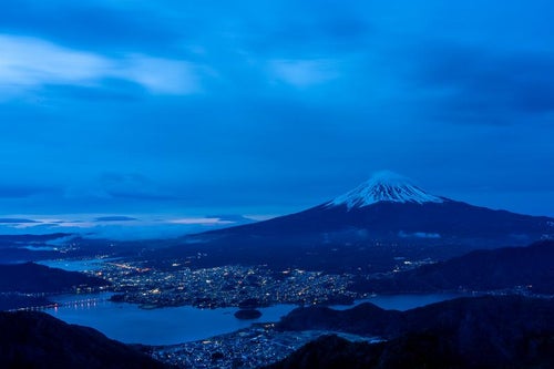 富士の夜 街明かりと共に輝く山の姿の写真