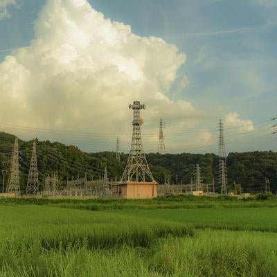 青空に映える送電線と田園の写真