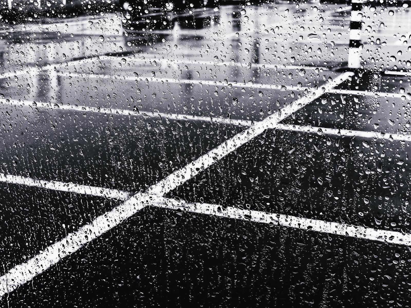 「大雨の中で車のガラスに飛び散る水滴」の写真
