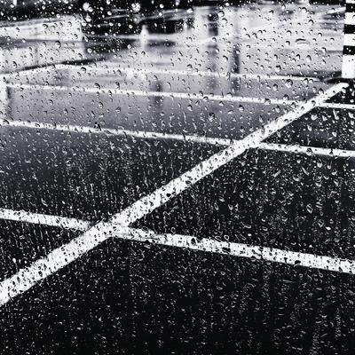 大雨の中で車のガラスに飛び散る水滴の写真