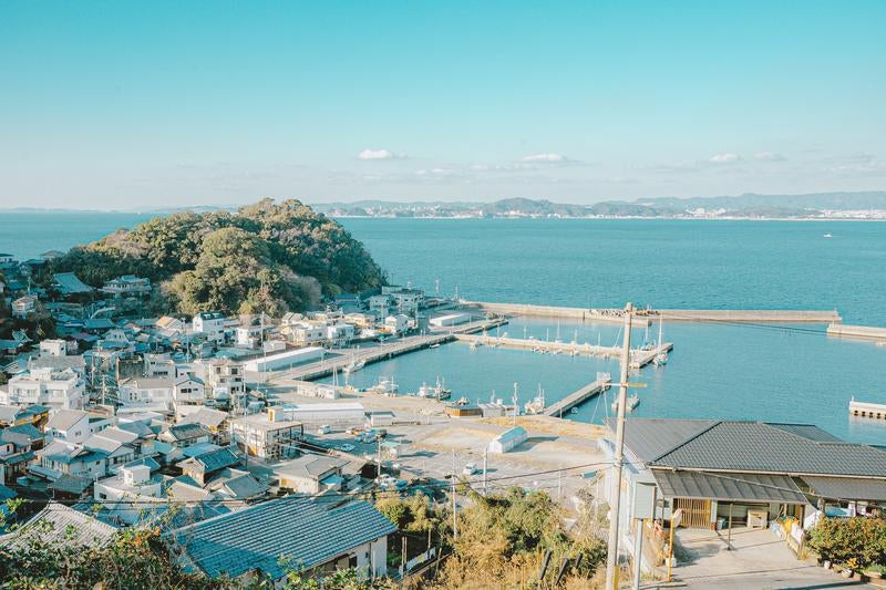緑豊かな山と青い海に囲まれた塩津漁港の写真