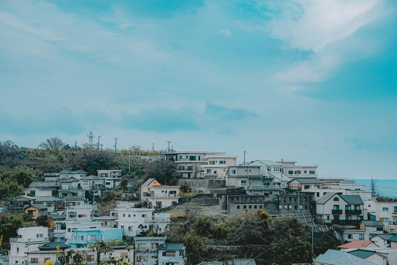 海を見守る住宅街の灯台のある風景の写真