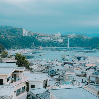 漁船が停泊する港の静けさと密集した住宅地の写真