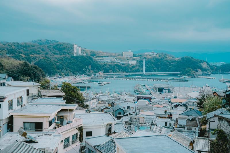 漁船が停泊する港の静けさと密集した住宅地の写真