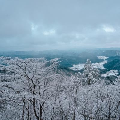 霞んだ山々が連なる冬景色の写真