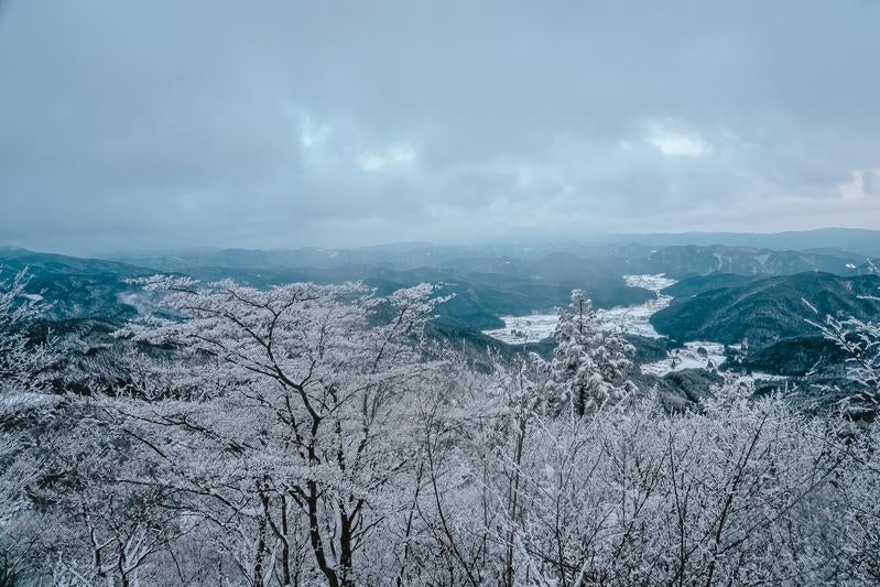 霞んだ山々が連なる冬景色の写真