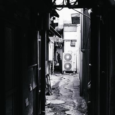 狭い路地裏のモノクロ写真の写真