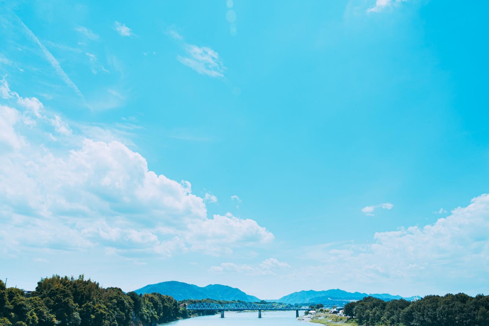 「青い空と自然が広がる川と橋」の写真