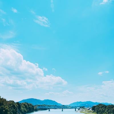青い空と自然が広がる川と橋の写真