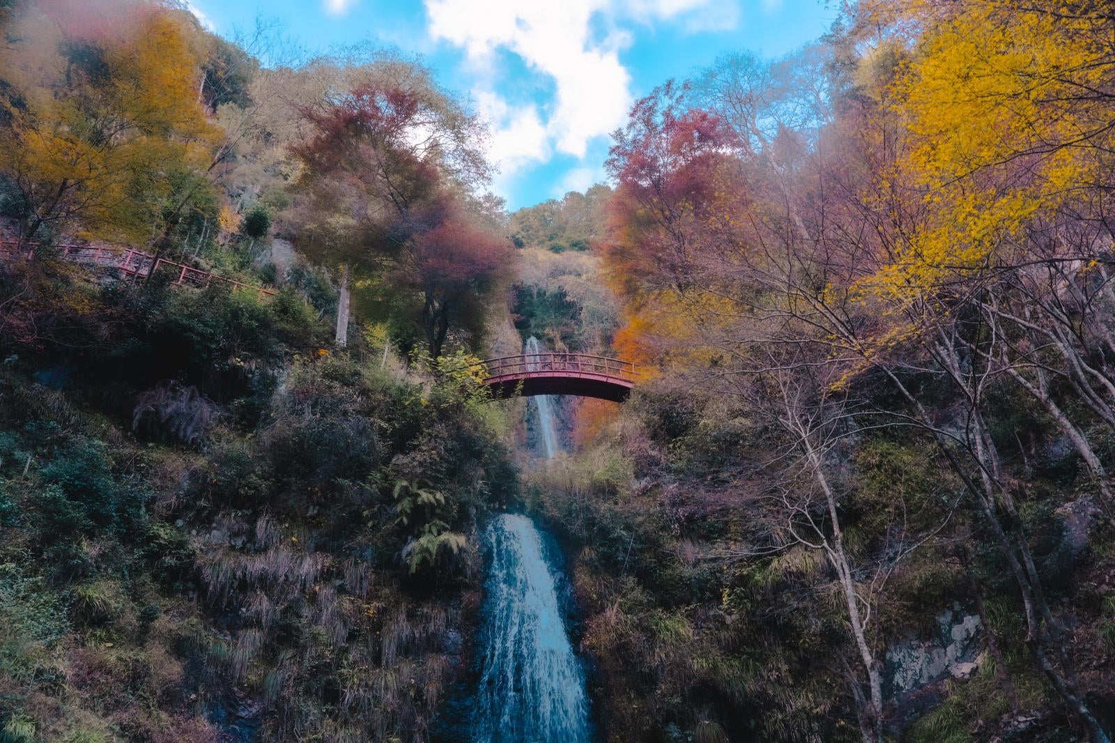 「秋晴れの空の下に広がる五宝滝と紅葉の絶景」の写真