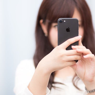 マットブラックカラーのスマートフォンを操作する女性の写真
