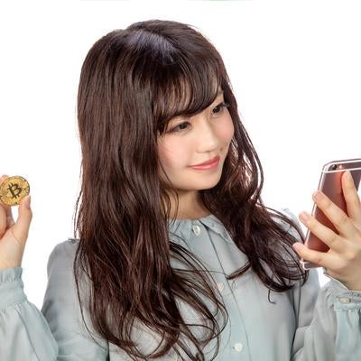 スマホでビットコインのトレードをする女性の素材