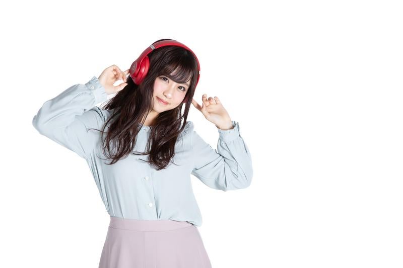 ヘッドフォンで音楽を聞きながらリズムに乗る女性の写真