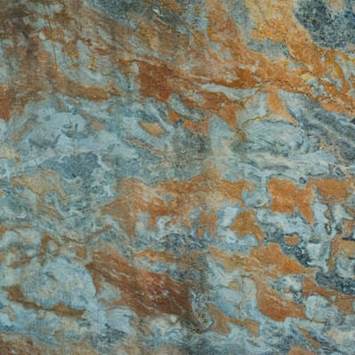茶色のシミとヒビが広がる石材の写真