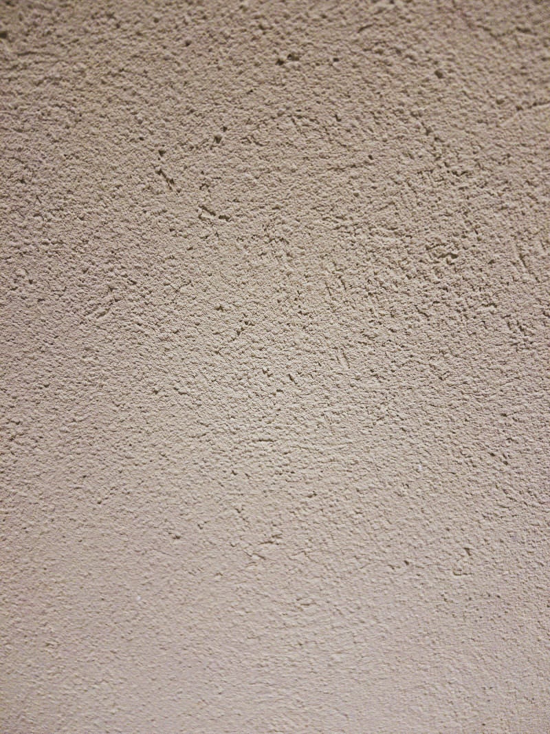 「シミが浮かぶ白いモルタルの壁(テクスチャー)」の写真