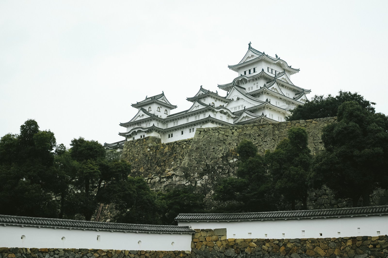「石垣の上にそびえる日本の城（姫路城）」の写真