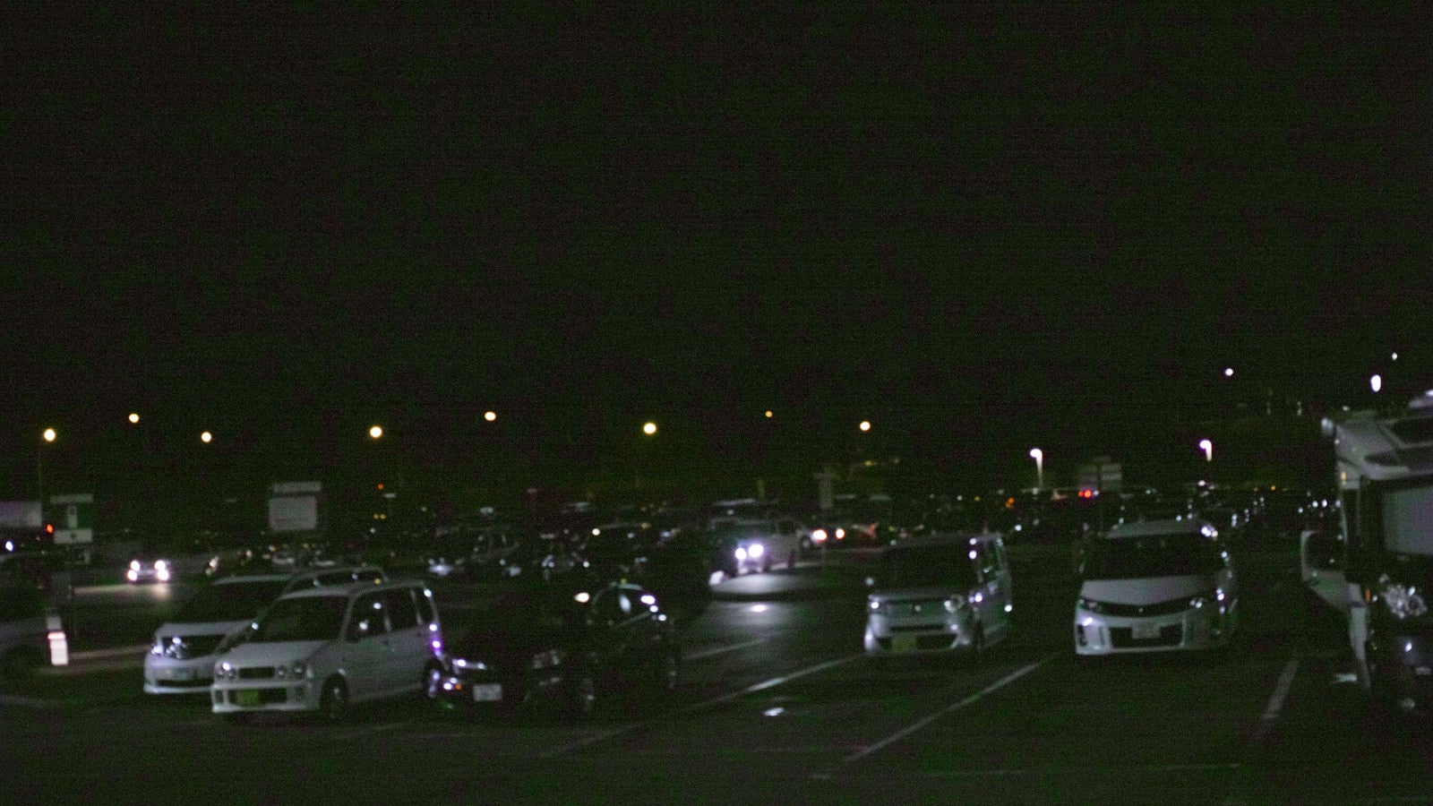 「夜のパーキングエリアに駐車する車」の写真