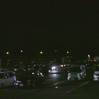 夜のパーキングエリアに駐車する車の写真