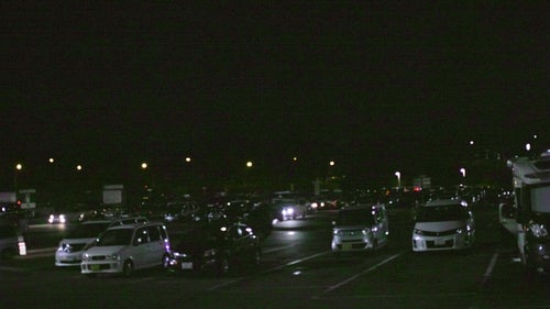 夜のパーキングエリアに駐車する車の写真