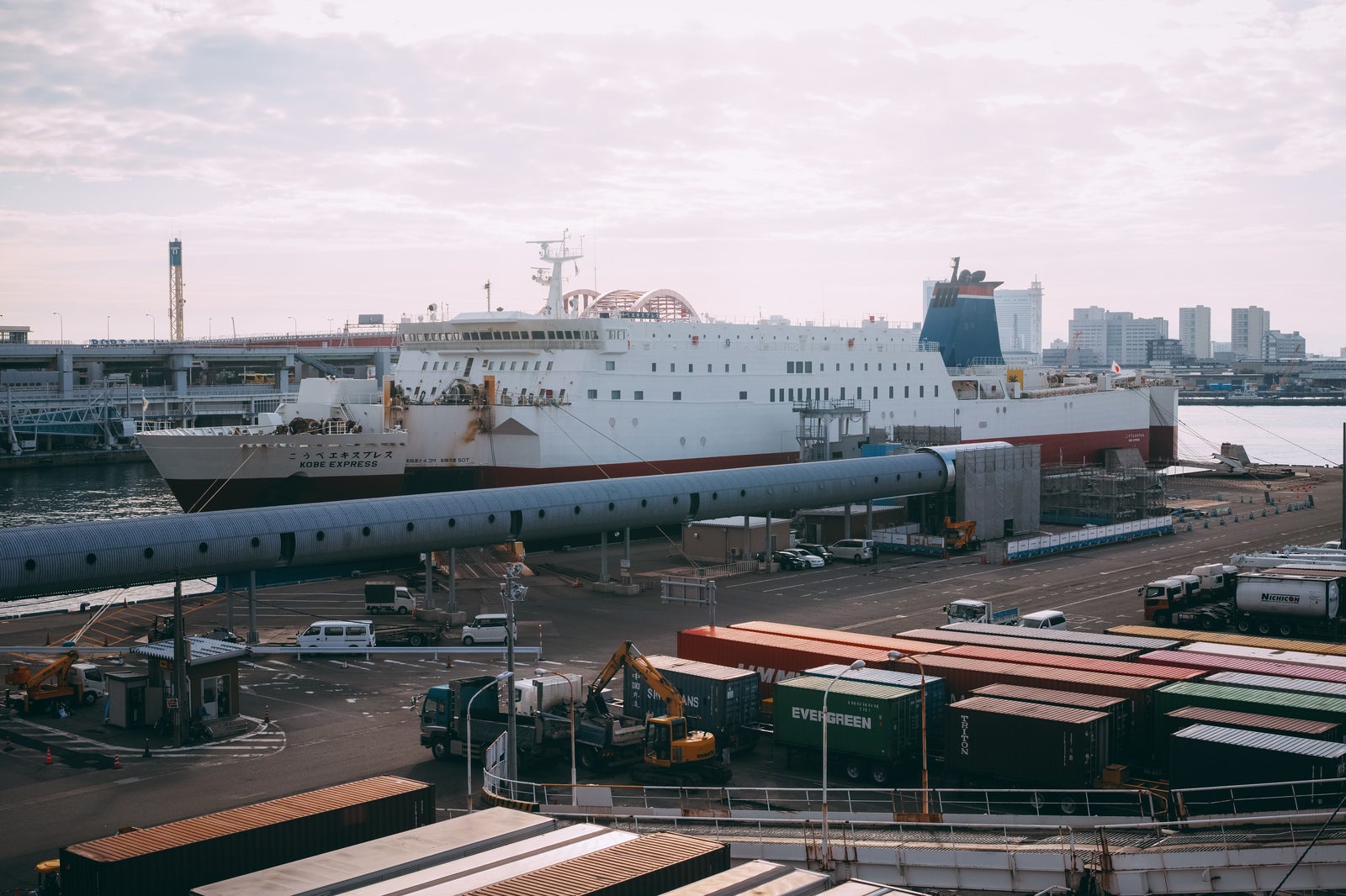 「雲が多い空と港に停泊する大型船」の写真