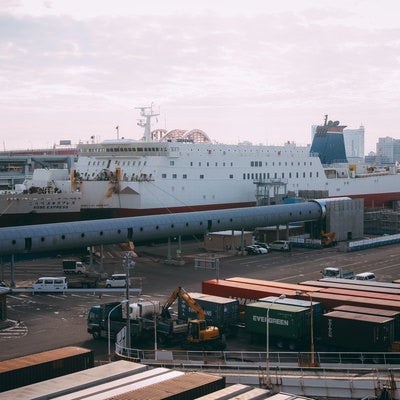 雲が多い空と港に停泊する大型船の写真