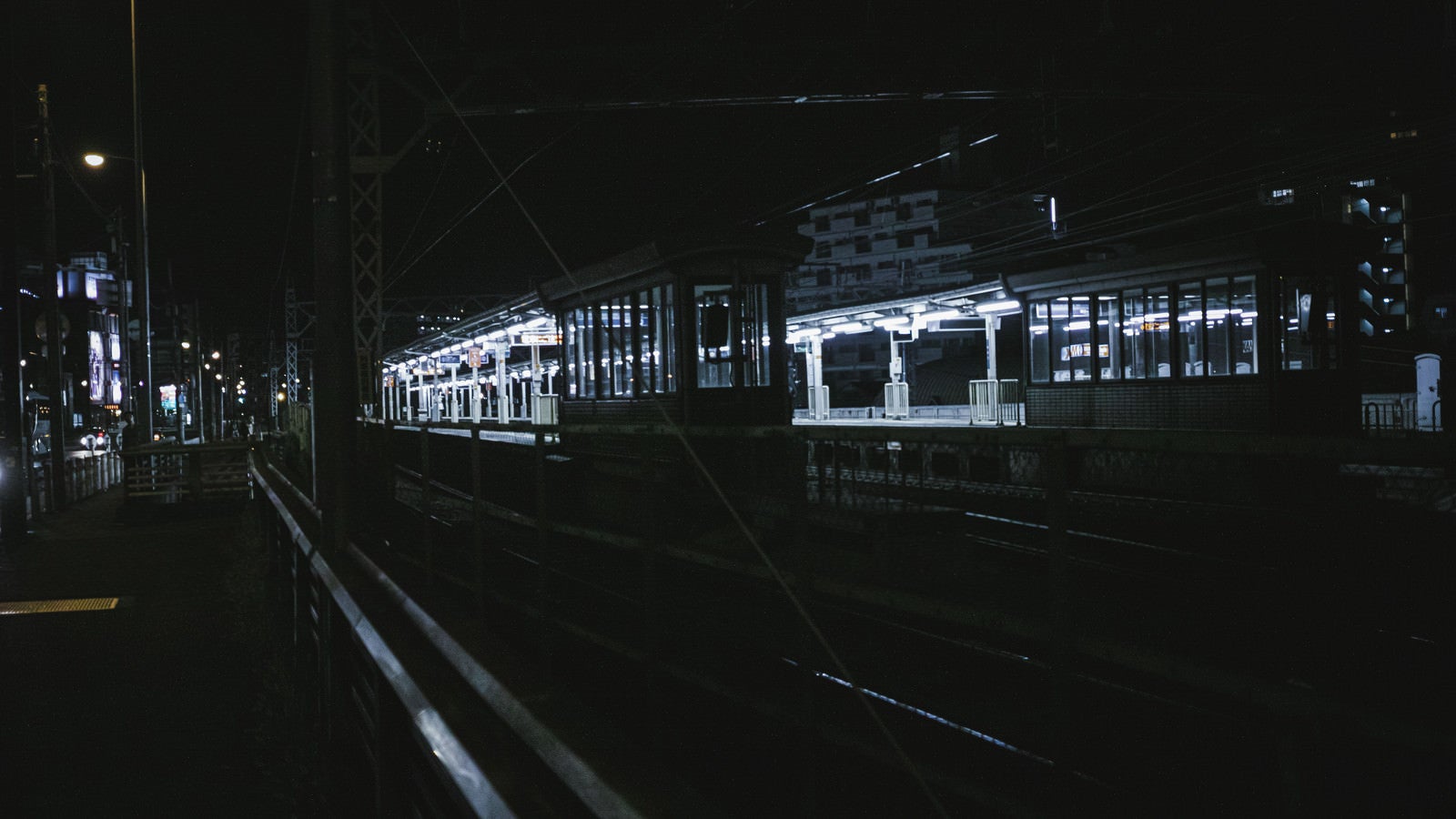 「照明が灯る無人の駅ホーム」の写真