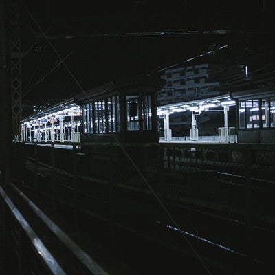 照明が灯る無人の駅ホームの写真