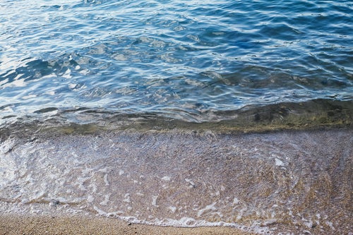 透明度の高い海の波打ち際の写真