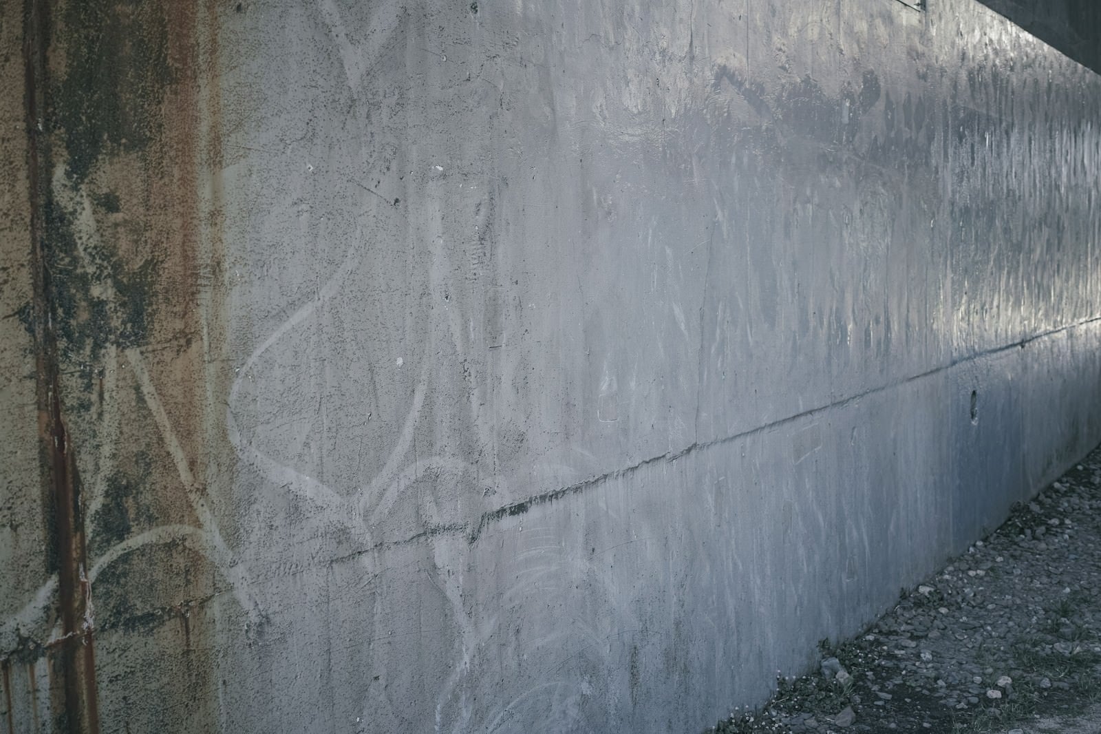 「うっすらと落書き後の残る殺風景な壁」の写真