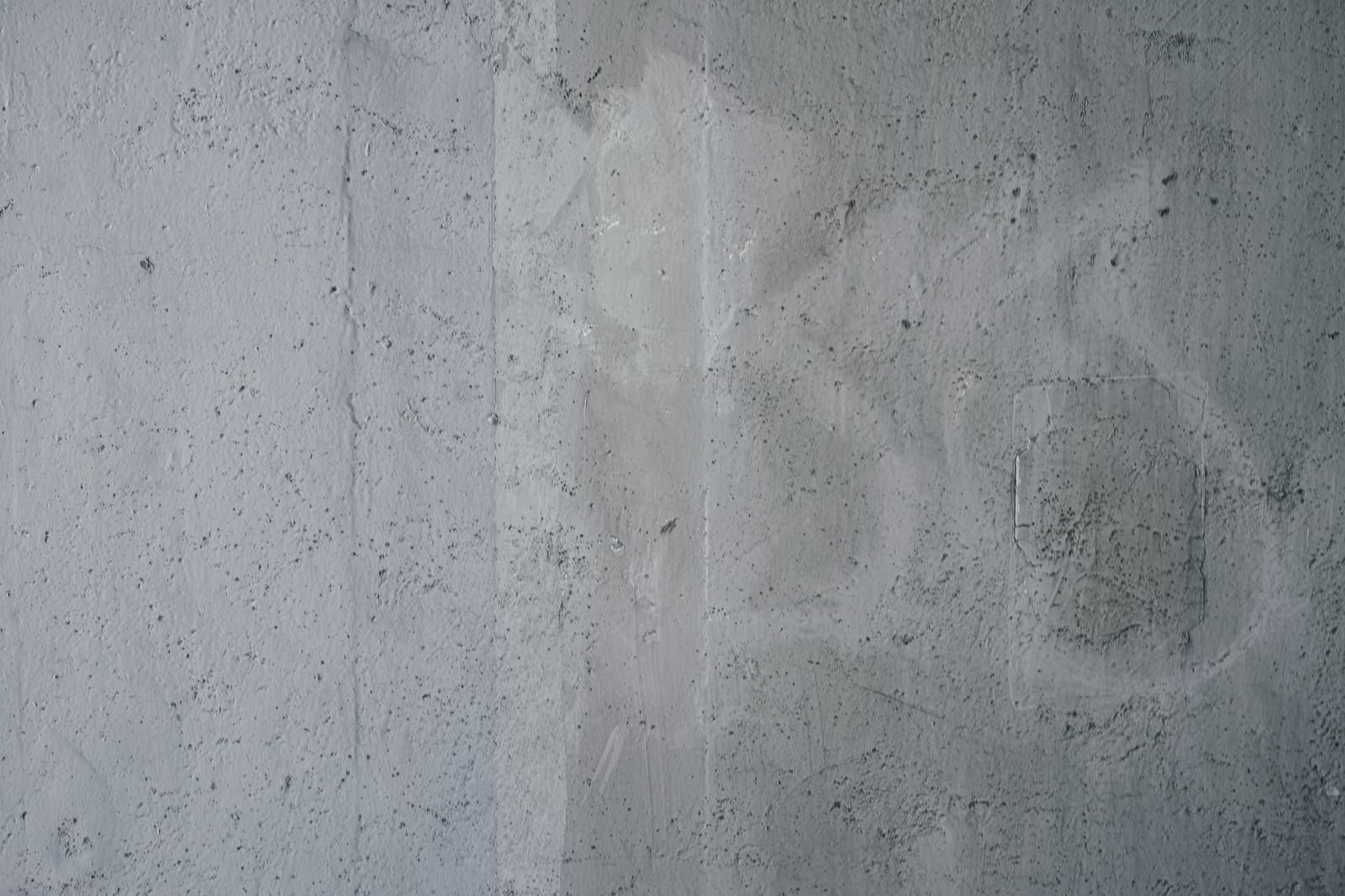 「小さな穴が開いた落書き跡の残るコンクリート壁（テクスチャー）」の写真
