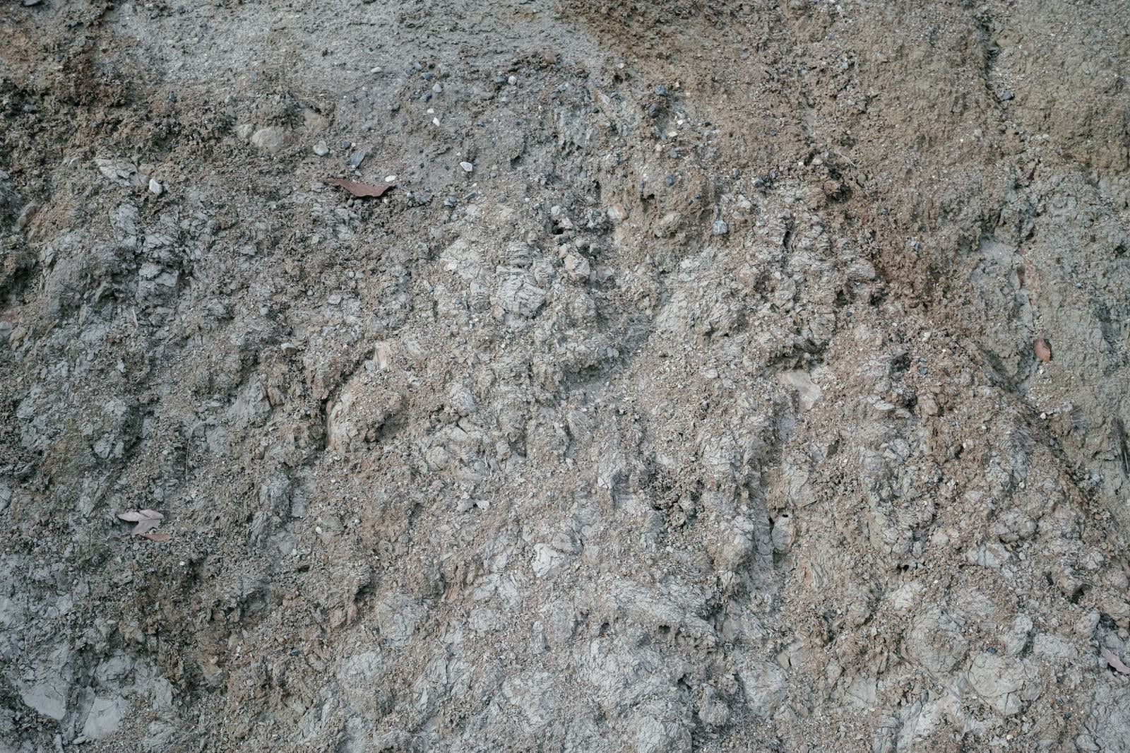 「不揃いな石が埋もれた地面（テクスチャー）」の写真