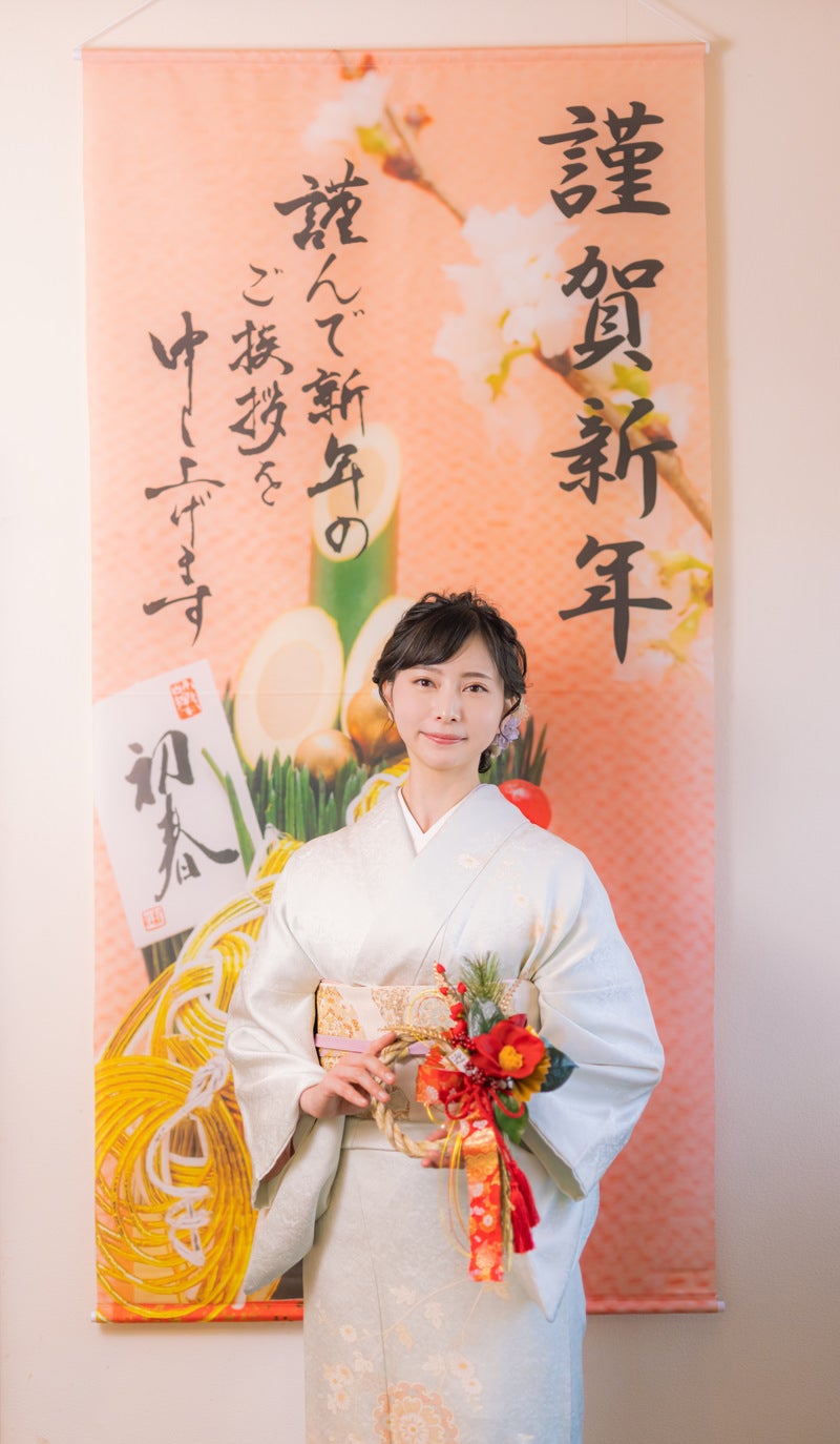 「謹賀新年の掛け軸と正月飾りを持つ着物の女性」の写真［モデル：yumiko］