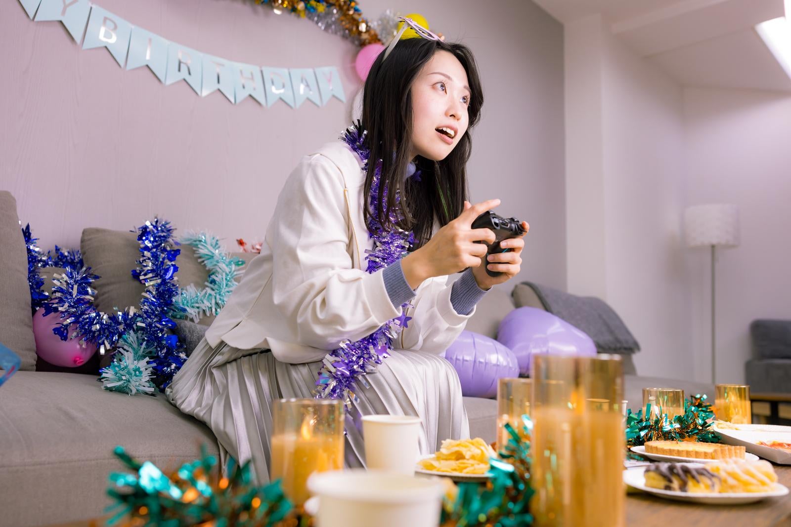 「生誕祭パーティーでゲームする女性」の写真［モデル：吉屋ゆり］